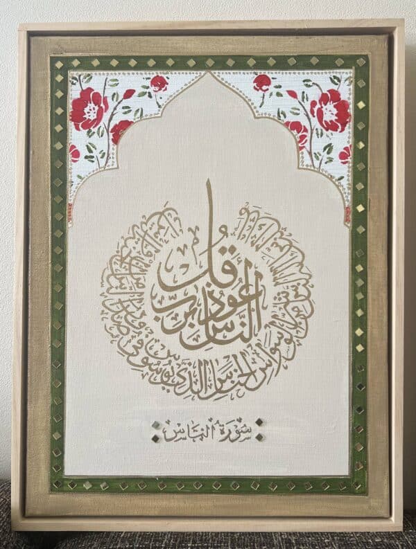 Framed artwork of Surah Al Falaq & An Naas in circular Arabic calligraphy, bordered by floral and geometric patterns. Cream background with red flowers and green accents at the top.